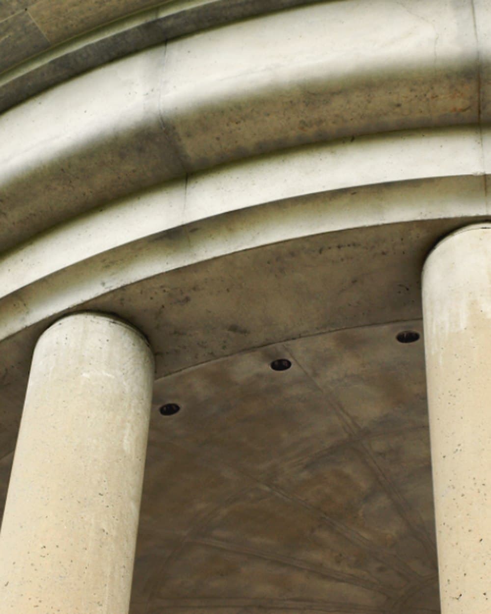 Arco y columnas de hormigón vistos desde abajo.